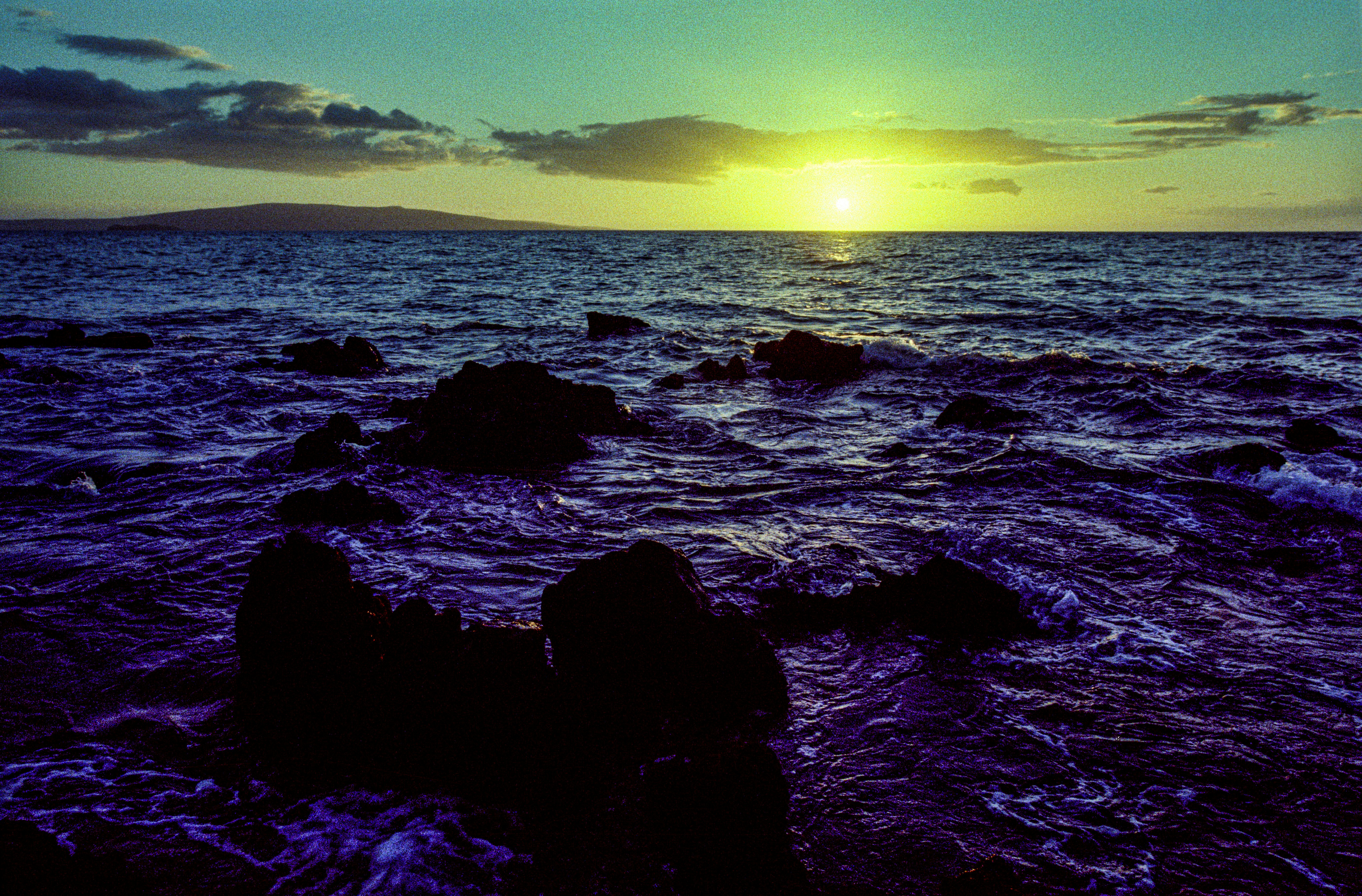 black rocks on sea under blue sky during daytime